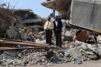 KOTELAM Chairman Jean Hubert Lindor (left) and Director Gervase Michel stand atop the rubble that was once the Magloire Ambroise branch in downtown Port-au-Prince.