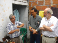 Juan Manuel Sanchez demonstrates the sandal production process to Oscar de Leon and Brian Branch.